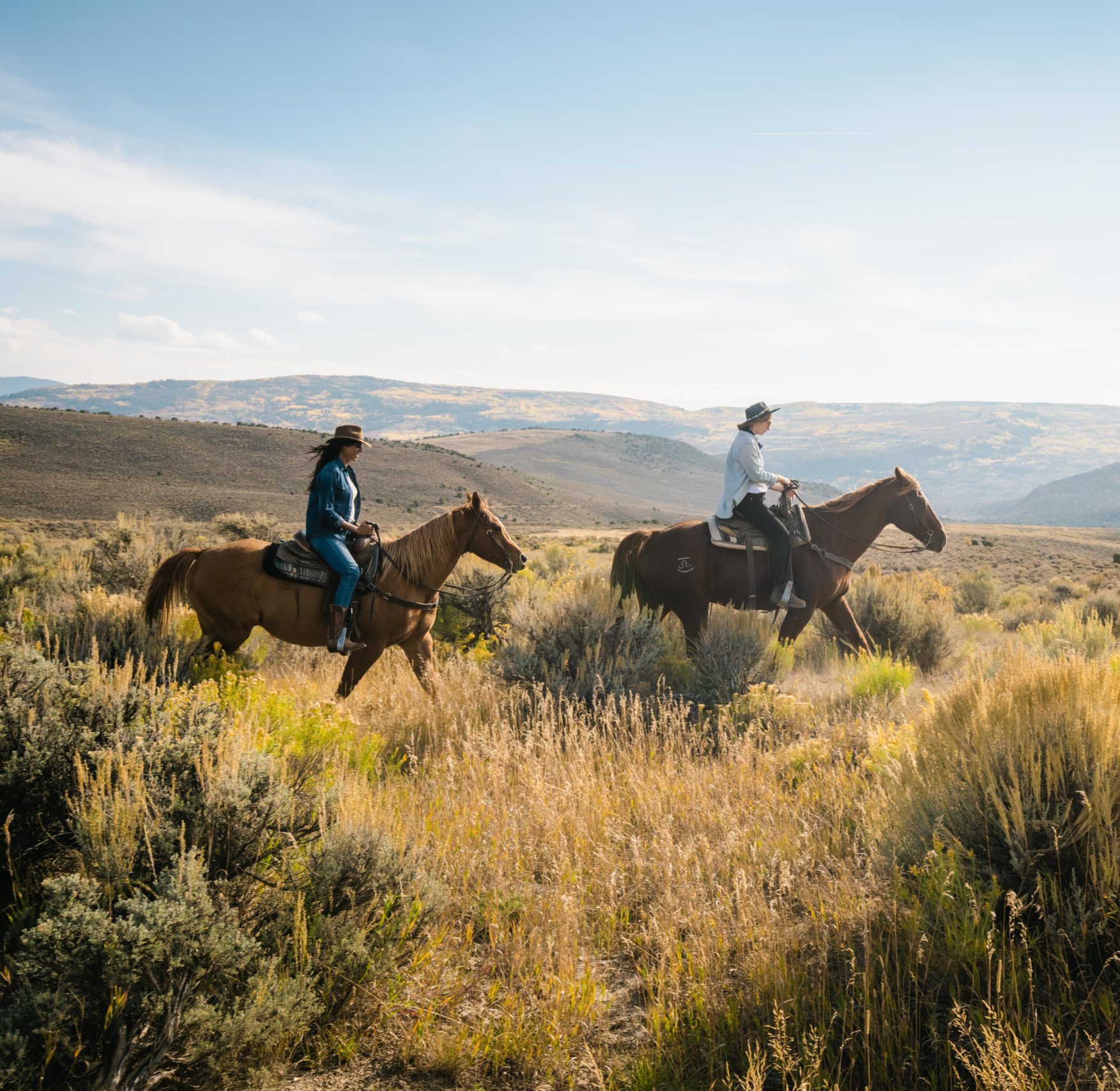 Three friends are horseback riding together during their stay at Collective Vail