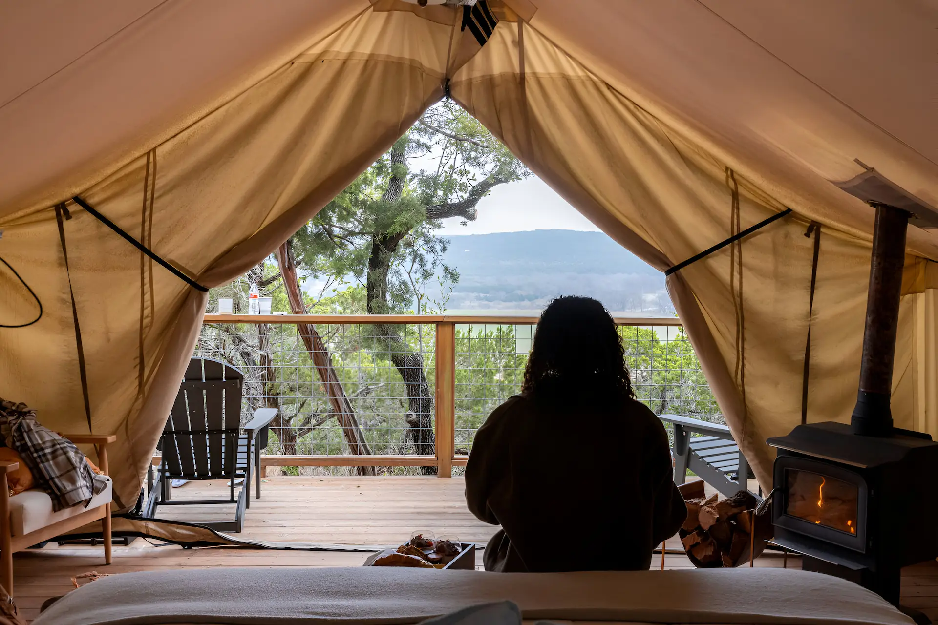 Woman waking up in the morning in her tent at Collective Retreats