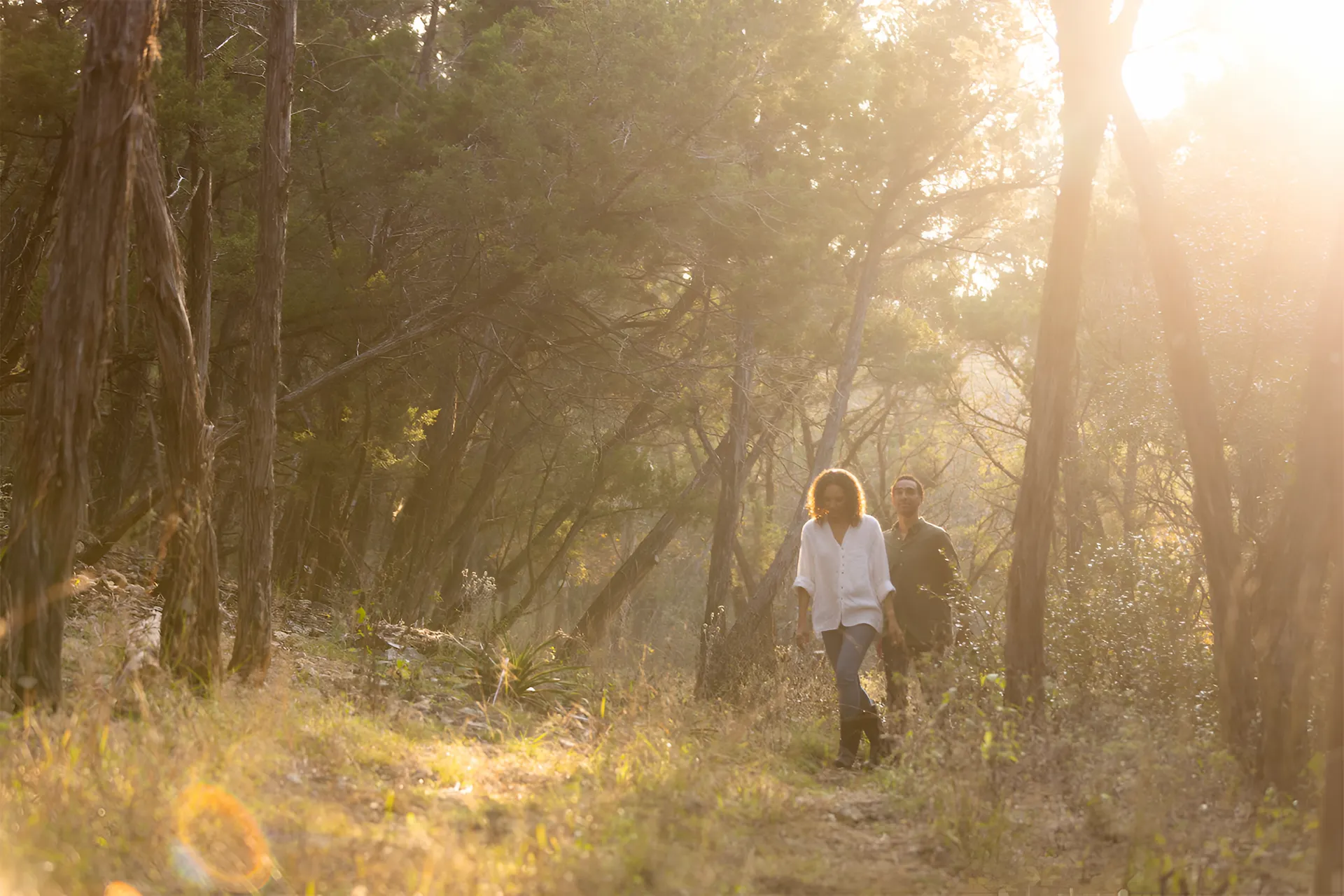 Couple walking through the forest at sunset in Collective Retreats