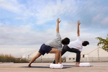 Men doing yoga exercise in the sunrise