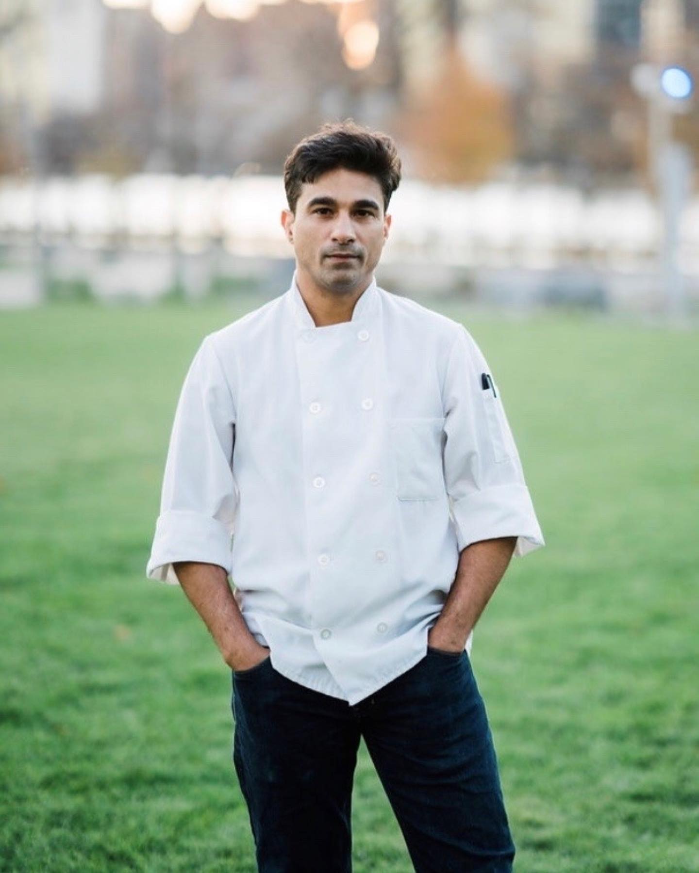 Chef Ali Loukzada in chef's coat standing in a field